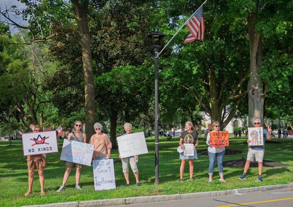 Group holding protest signs in a park