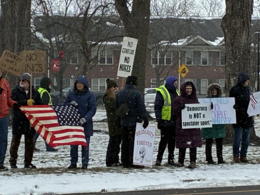 People protesting with various signs in snowy weather.