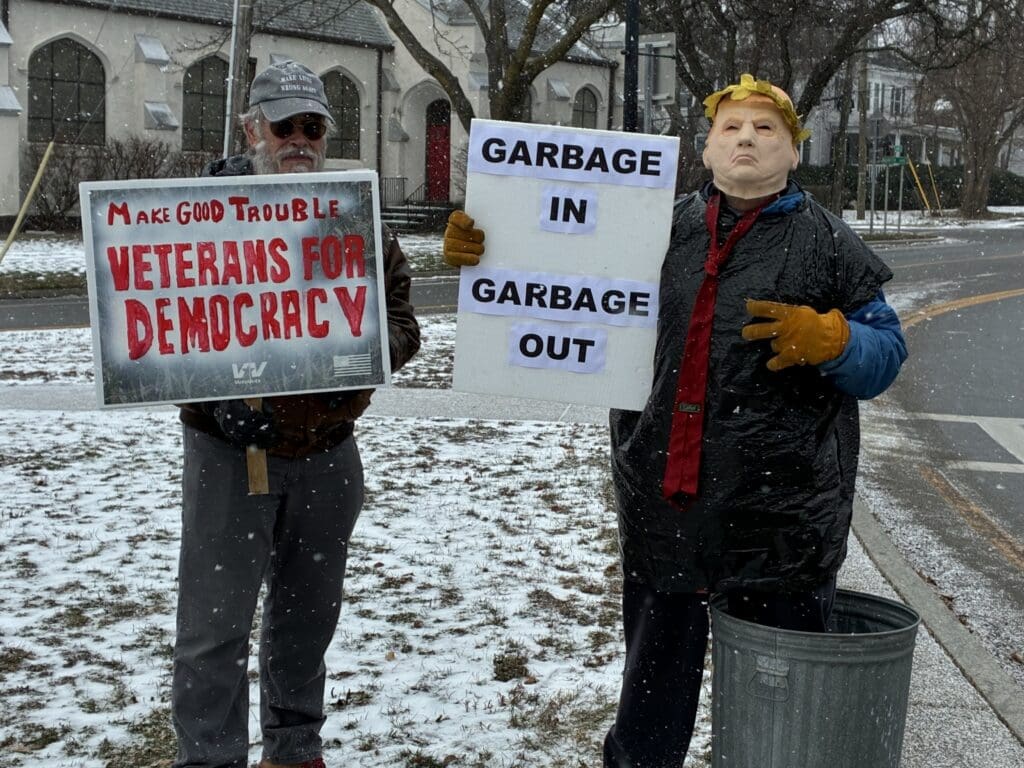 Protesters holding signs in snowy street.