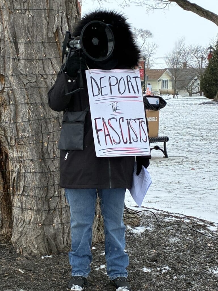 Protester holds sign: Deport the fascists.