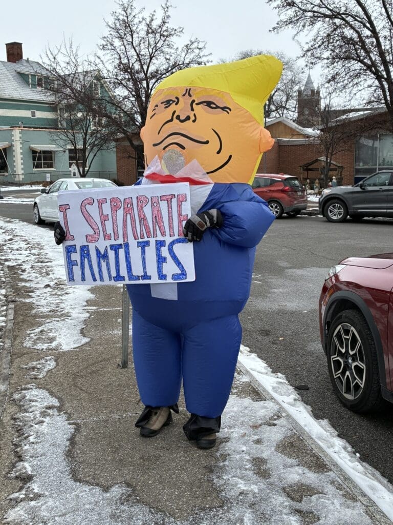 Protester in costume holds 'I Separate Families' sign.