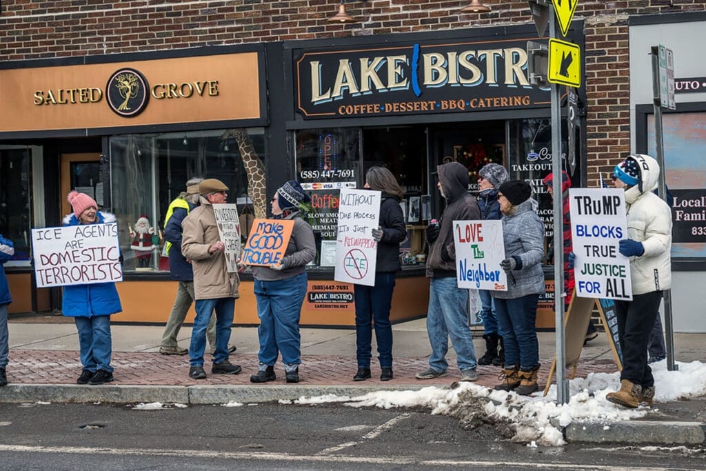 Protesters holding signs on snowy city sidewalk
