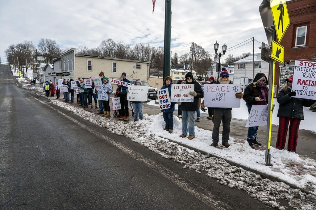 Protesters holding signs on snowy sidewalk