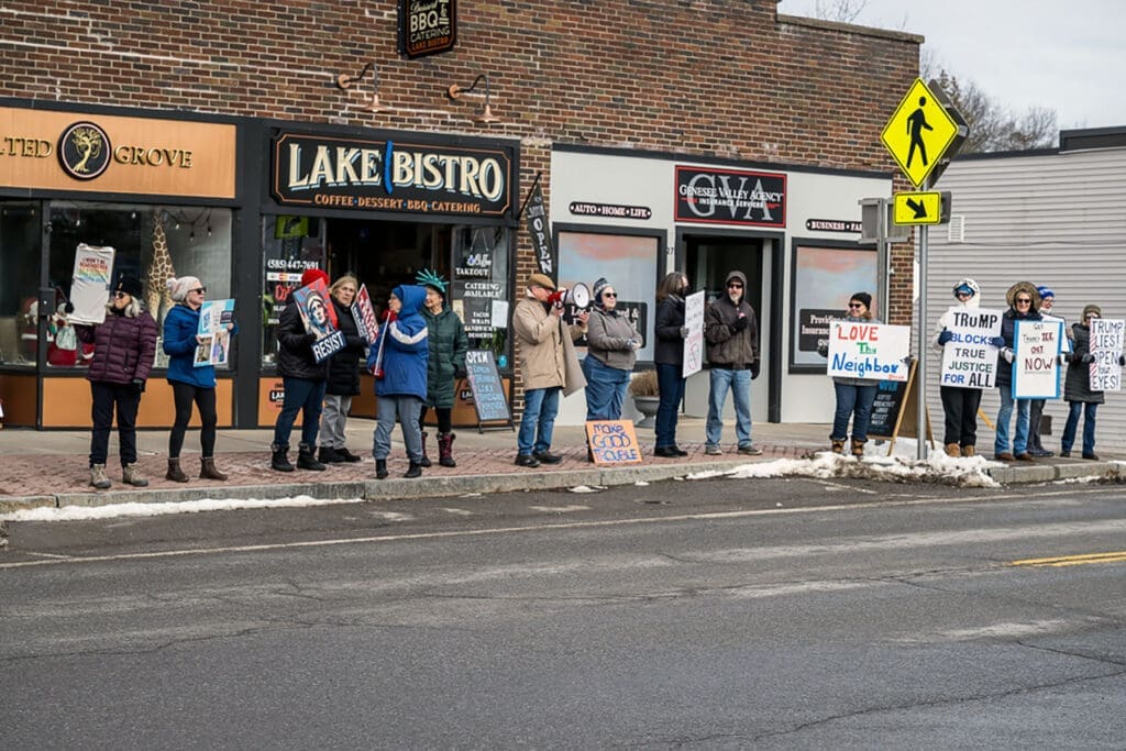 Small group protesting on sidewalk with signs