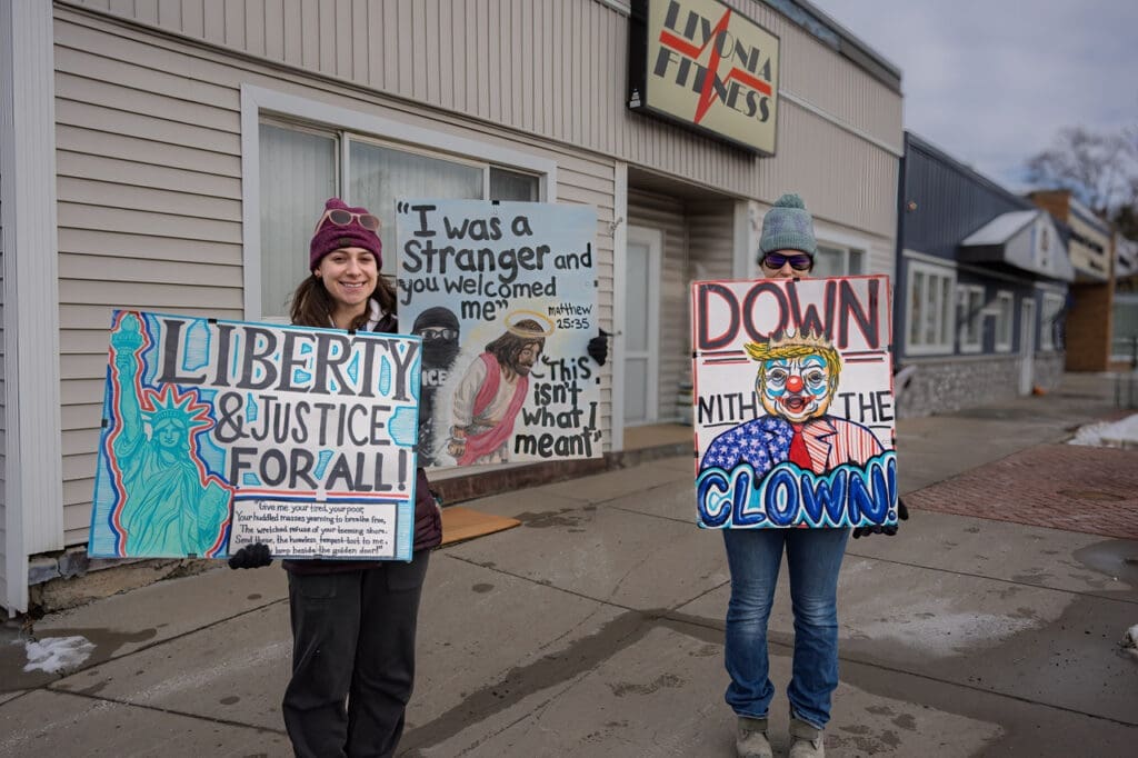 Protesters holding signs for justice and against leaders.