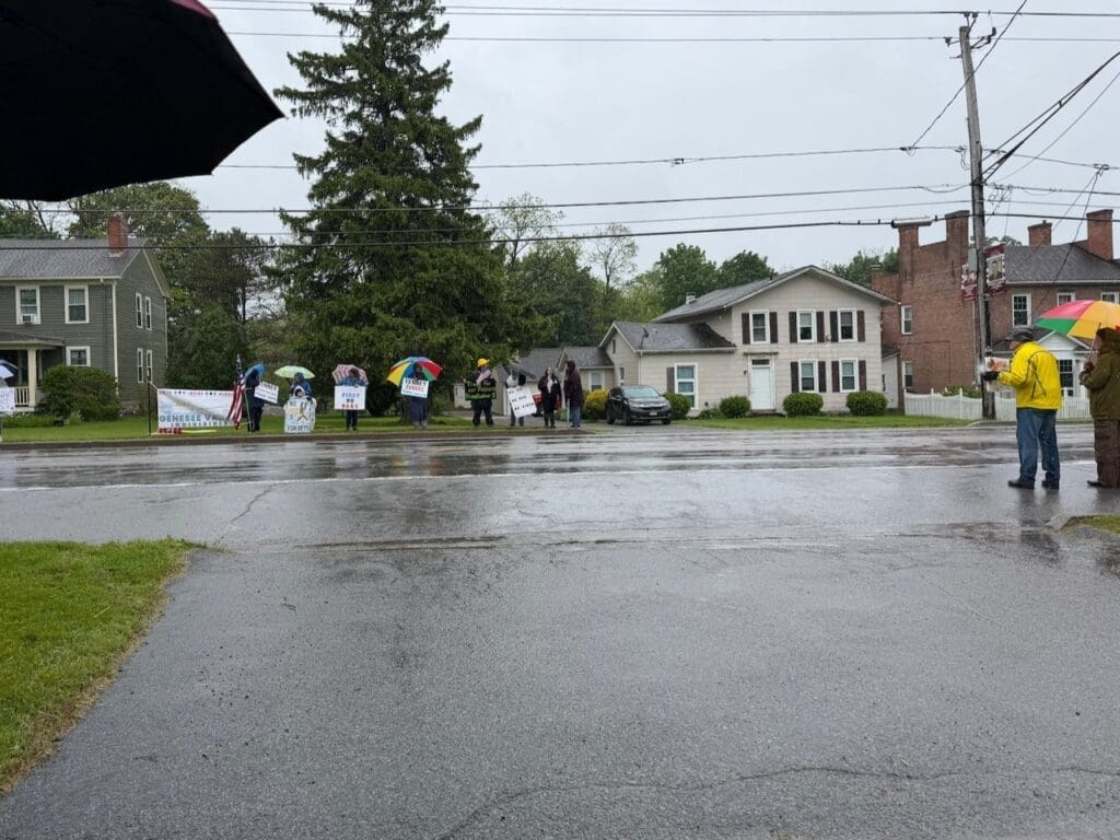 People protesting with umbrellas on rainy street
