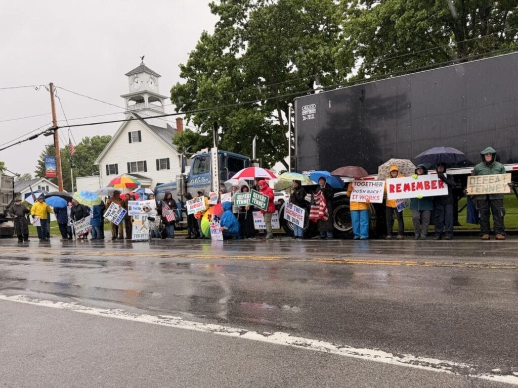 Rainy street protest with umbrellas and political signs