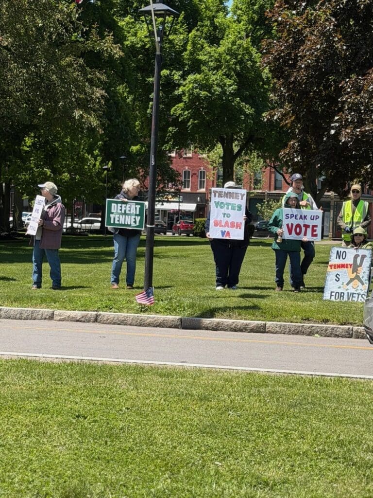 Protesters holding political signs in park