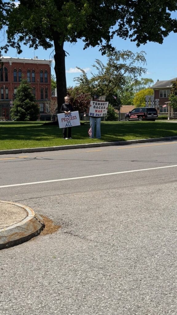 Two protesters holding signs on small-town street