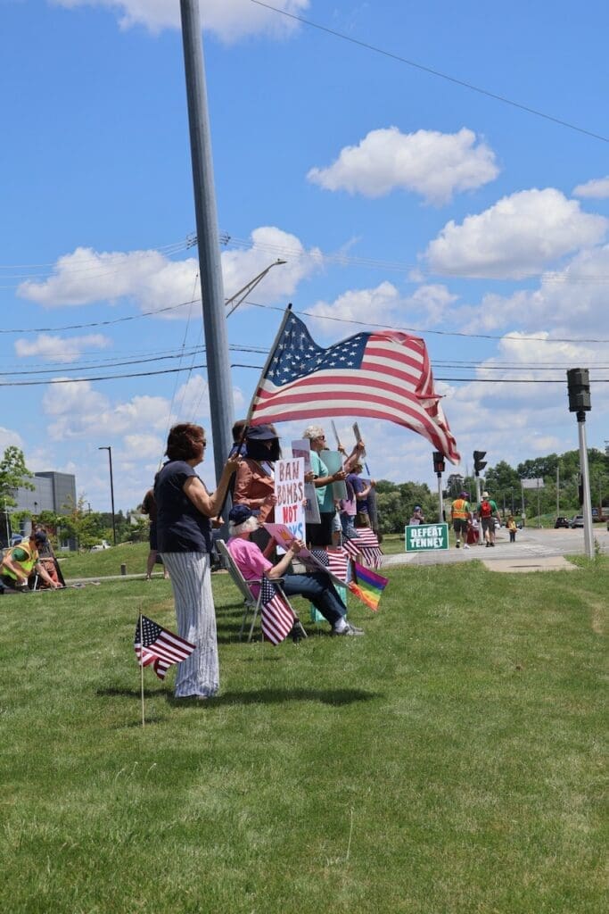 Protesters with American flags and signs at outdoor rally