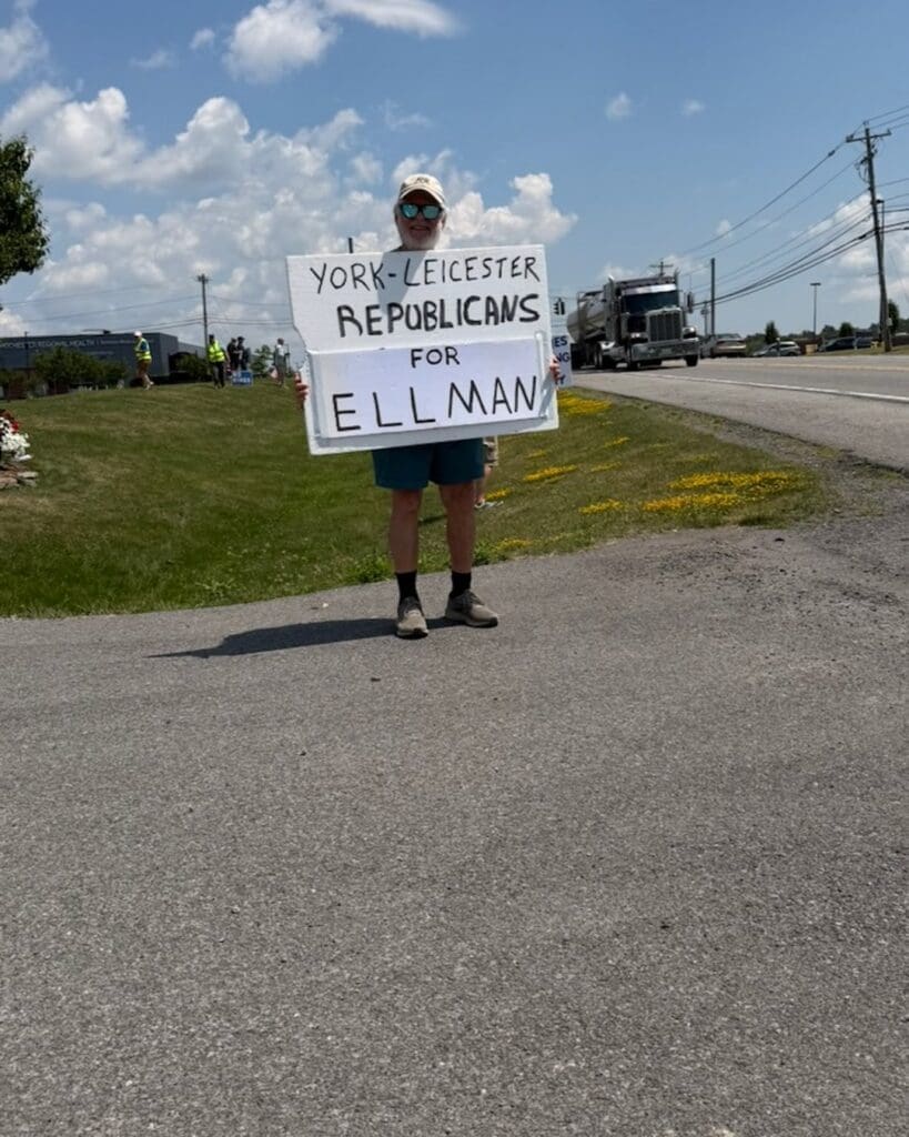 Person holding York-Leicester Republicans for Ellman sign roadside