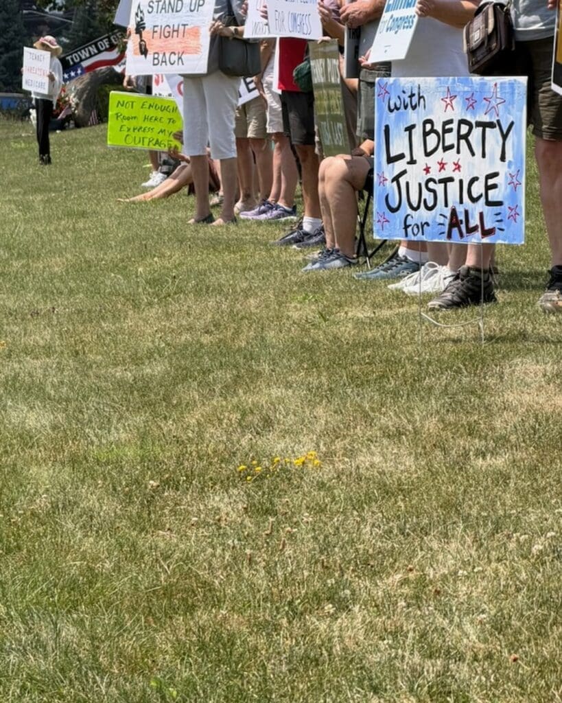 Protesters holding signs for liberty and justice outdoors
