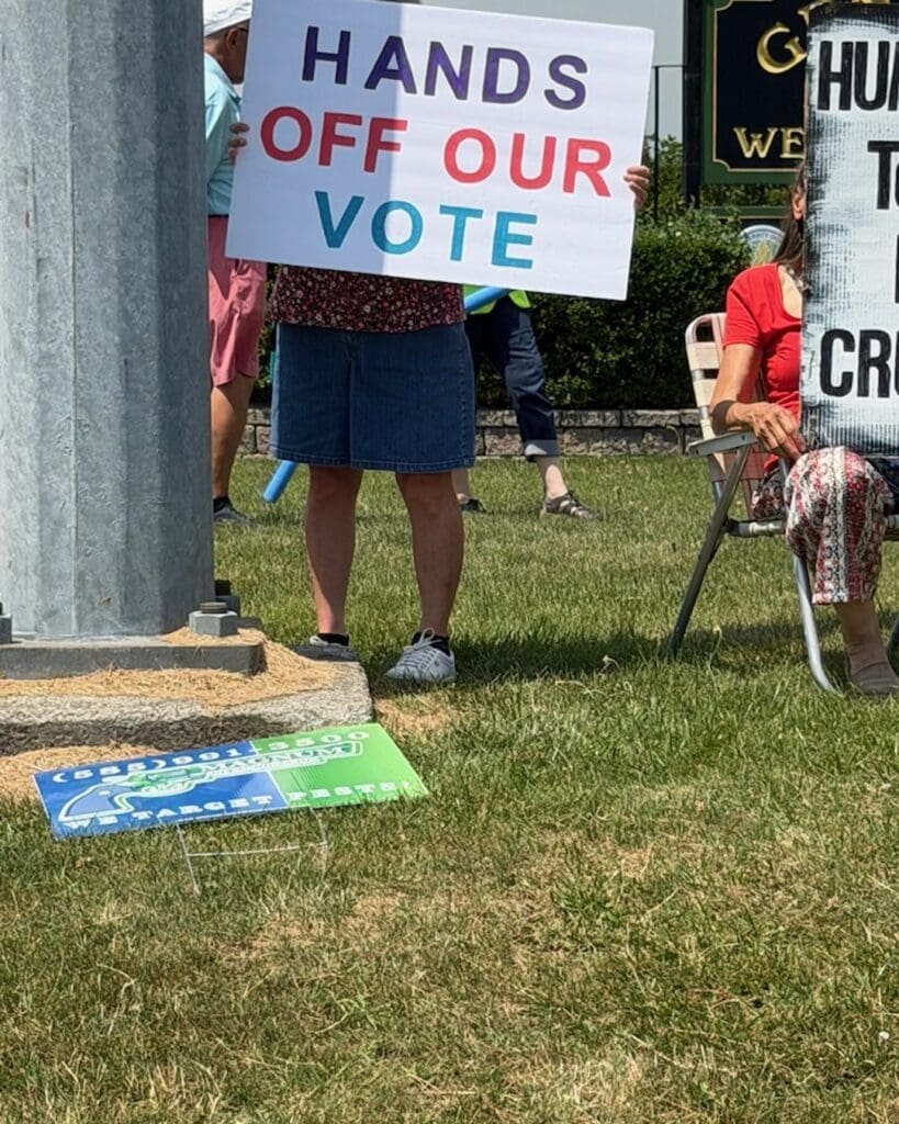 Protesters holding Hands Off Our Vote sign at rally