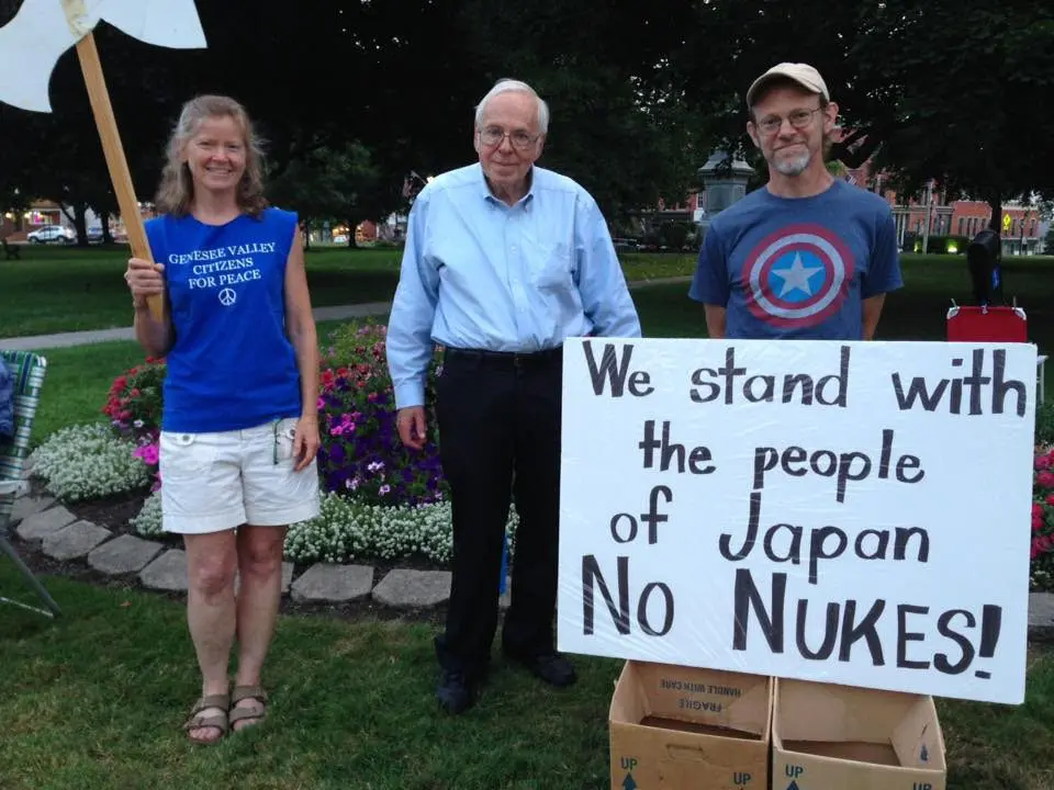 Three people holding anti-nuclear sign at peace rally