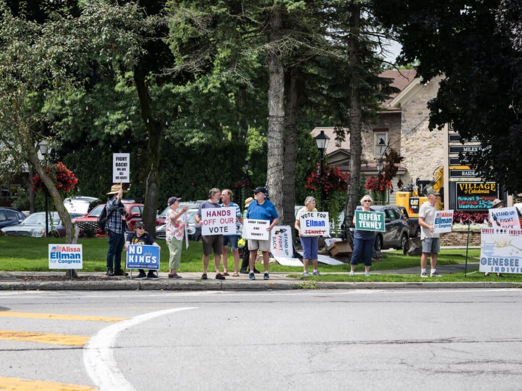Protesters holding political signs on a small-town street