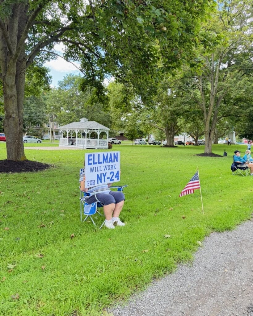 Person holding Ellman NY-24 campaign sign in park